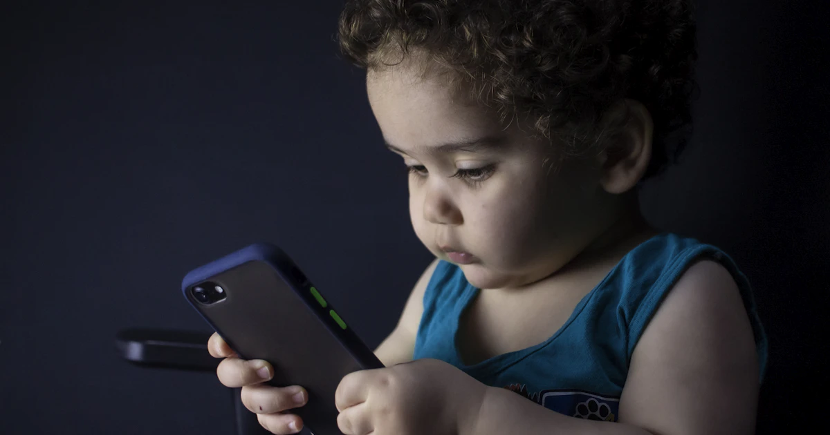 boy using an iPhone, with Screen Time set to block adult content on iPhone