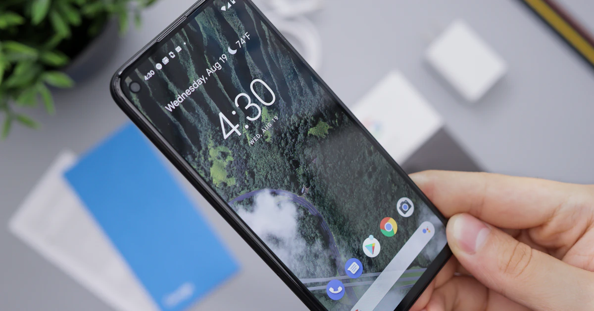 Hand holding a black Android smartphone to clear the app cache