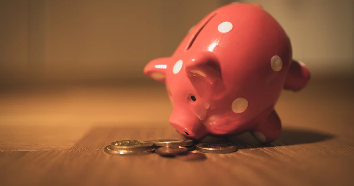 Pink piggy bank with coins