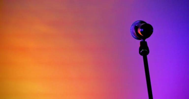 Microphone on stage under warm orange lights, a metaphor for celebrities on X